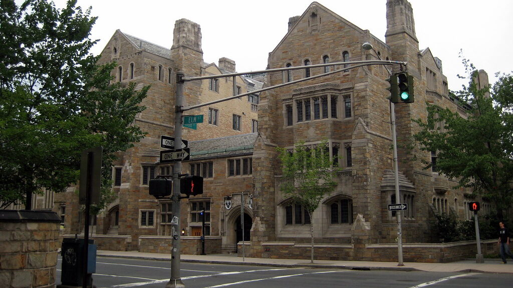 Students walking through a grand Gothic collegiate courtyard at a UK university