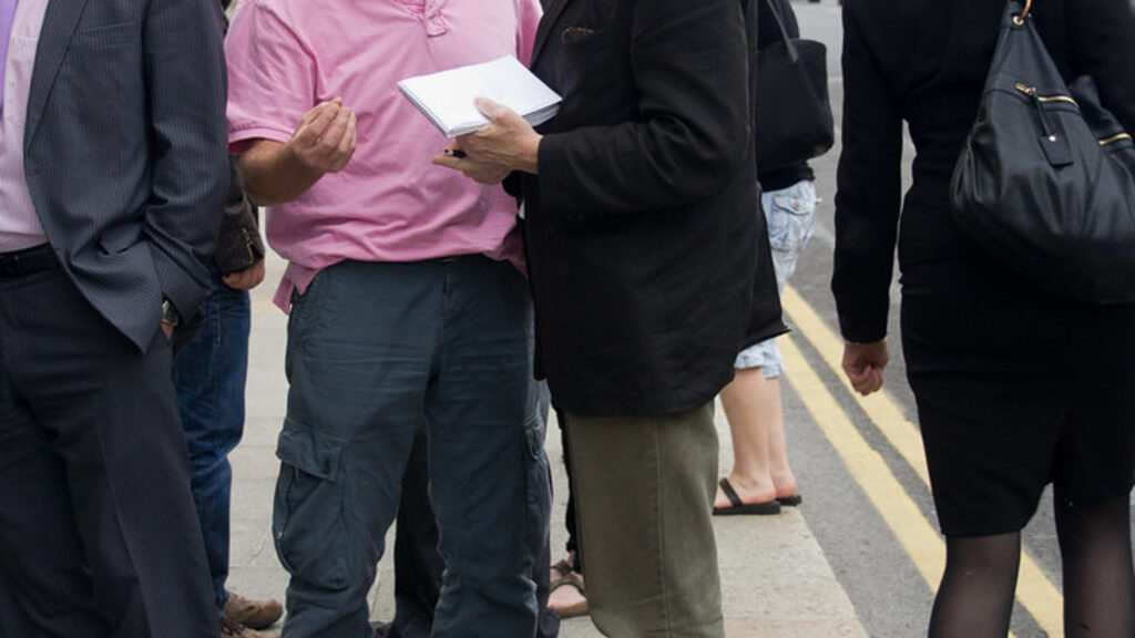 Parent reviewing financial documents and using a calculator while choosing a British school